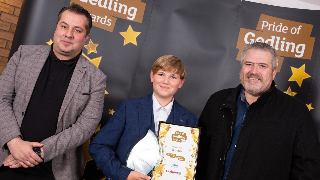Young Achiever Award winner, Freddie Vokes (Centre) holding his Pride Of Gedling Award and certificate with representatives from Gedling Eye and This is Gedling on either side.